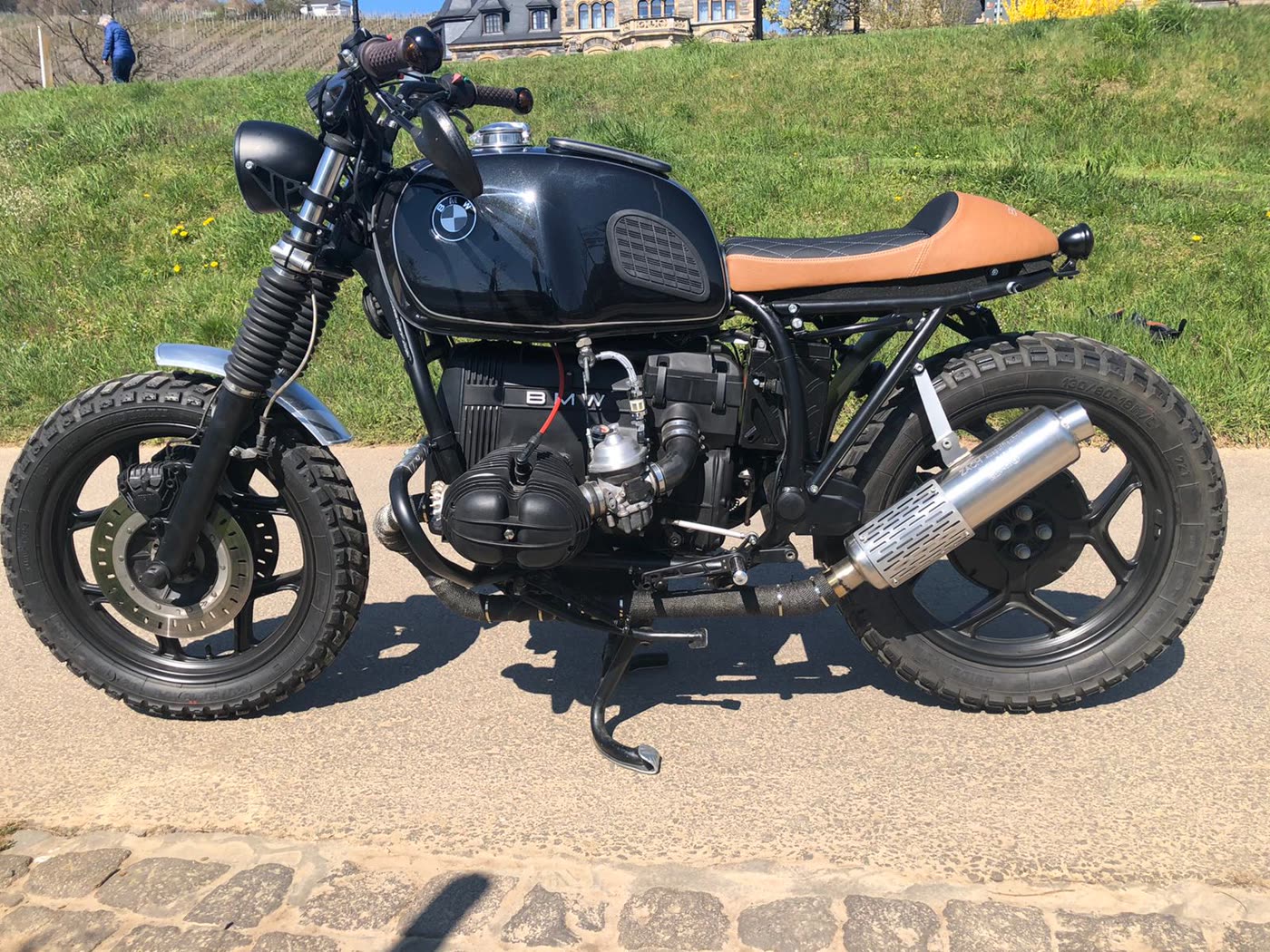 Cafe-Racer Motorrad braune Sitzbank vor Schloss